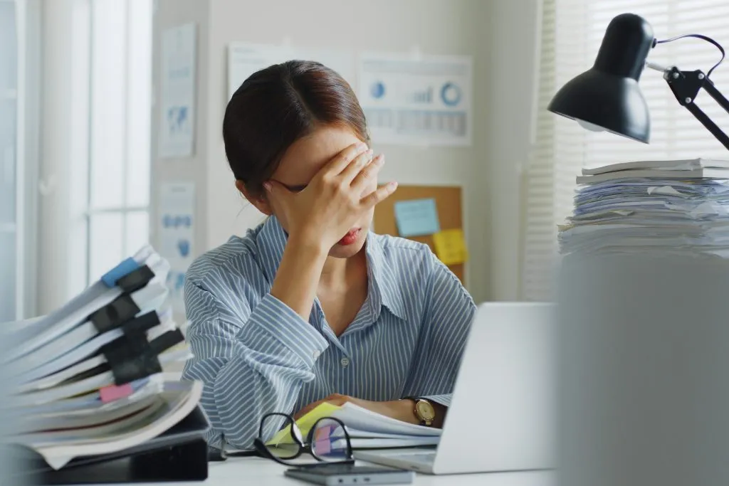 femme avec des migraines douloureuses au travail