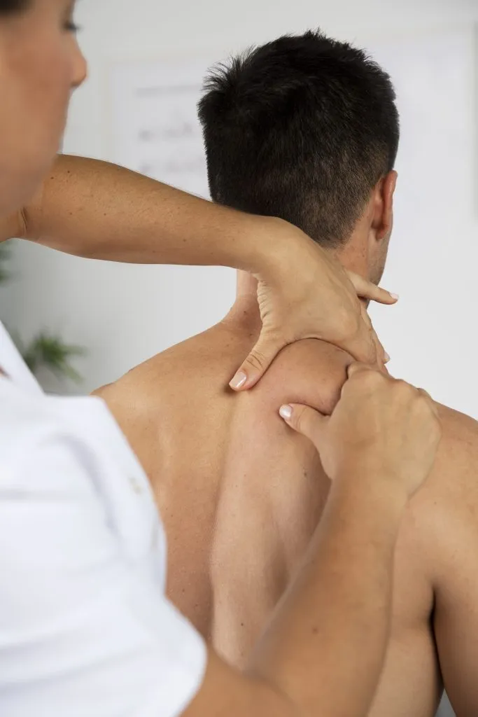 Kinésithérapeute accompagnant un patient pendant une séance de rééducation