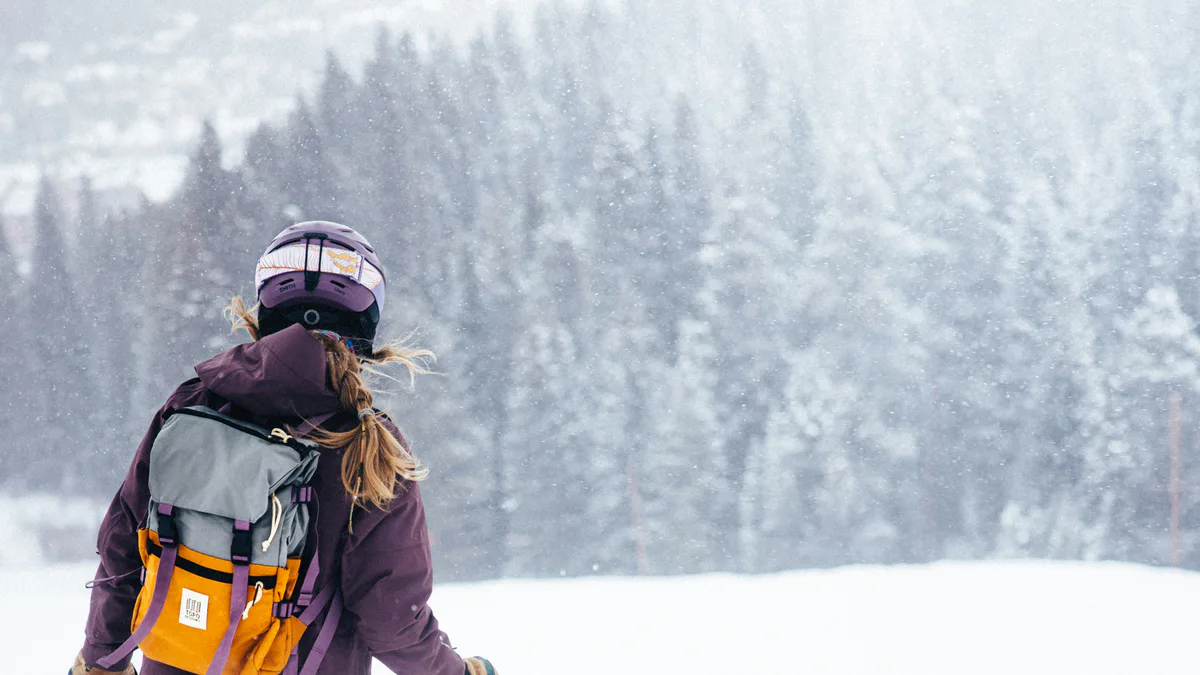 Skieuse équipée sur une pente enneigée